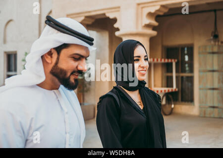 Happy couple spending time in Dubai. man and woman wearing traditional clothes making shopping in the old city Stock Photo