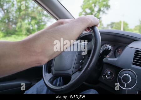 Drivers men hands on steering wheel, day time Stock Photo