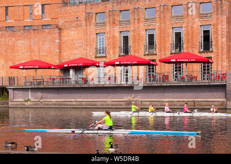 skiffing sculling and rowing on the the river Avon as it passes in front of the Royal Shakespeare Theatre Stratford upon Avon Warwickshire Stock Photo