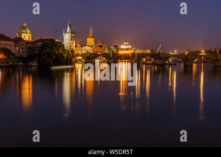 Charles Bridge between districts Old Town and Lesser Town at night in Prague. Old Town tower and historic stone bridge over the Vltava illumination