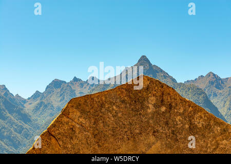 A sacred inca stone in Machu Picchu with resemblance or imitation of the Huayna Picchu, Yanantin and Putukusi Andes mountain peaks, Cusco Region, Peru. Stock Photo