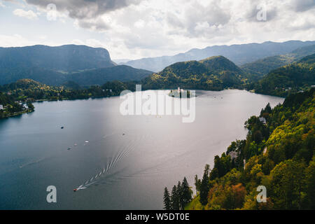 Aerial view of the lake Bled in Slovenia surrounded by mountains and forests and the Bled island. With resorts, hotels, houses, parks and beaches loca Stock Photo