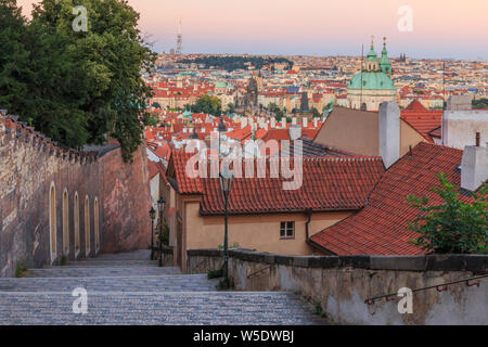 City view from the Prague district Lesser Town. Steps from the Prague Castle down to the old town. Historical masonry along the castle overlooking old Stock Photo
