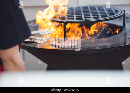 Preparing juicy burger cutlets on grill Stock Photo