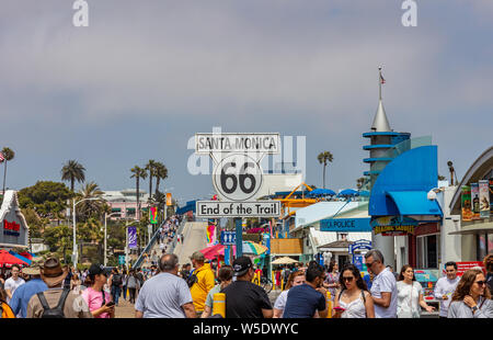 Los Angeles California USA. May 31, 2019. Santa Monica pier and Route 66 End of the trail, white color  sign. People walking at pier, blue sky backgro Stock Photo