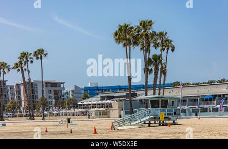 California USA. May 30, 2019. Palm trees and hotels on Marina del Rey sandy beach. Lifeguard hut, blue sky. Sunny spring day Stock Photo