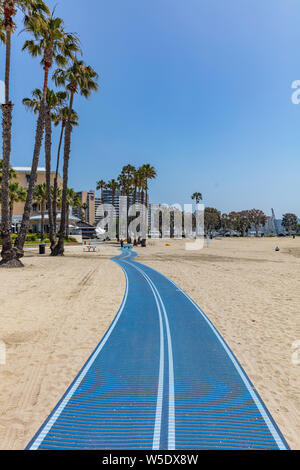 California USA. May 30, 2019. Walkway blue color on Marina del rey sandy beach, Palm trees and hotels. Sunny spring day Stock Photo