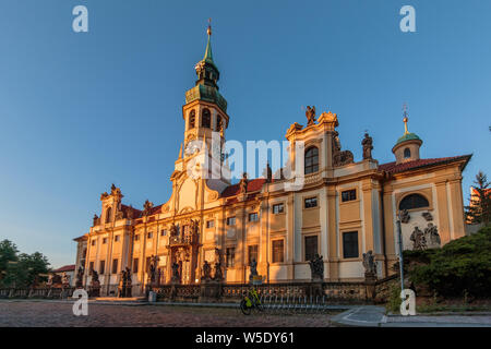 Historical Capuchin Church Loreta from Hradcany Square near the Prague Castle. View of the historic baroque building complex from the right in the eve Stock Photo