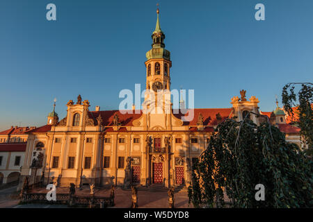 Direct view of the historic Baroque building complex in the Czech capital of in the evening sun with blue sky. Capuchin Church Loreta from Hradcany Stock Photo