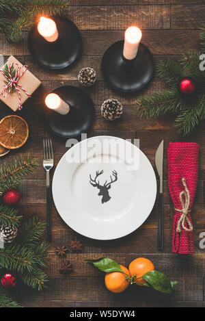 Christmas Table Setting Vintage Or Rustic Style With Candles, Wooden table, Empty Plate And Tangerines Stock Photo