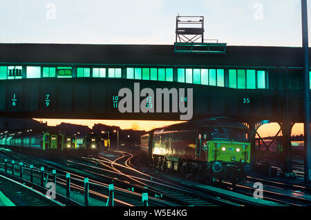 A class 47 diesel locomotive number 47712 and a host of slam door electric multiple units in the yard at Clapham Junction as dusk falls. 5th November 1992. Stock Photo