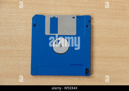 Blue obsolete computer diskette on wooden background Stock Photo