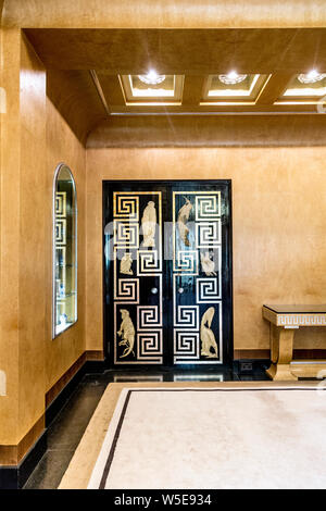 Beige walls and black lacquered door with Greek key pattern, detail of the art deco dining room at Eltham Palace, Eltham, UK Stock Photo