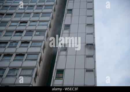 London, UK. 28th July 2019. Eight fire engines and around sixty firefighters from London Fire Bridge tackle a “small” tower block blaze which started at 8:40pm on the 8th floor in the rubbish chute area of Eddystone Tower, a 22-floor high-rise building, part of Deptford’s Pepys Estate in south east London. A number of residents had left the building before firefighters arrived on the scene, with others remaining “safely in their flats”. Credit: Guy Corbishley/Alamy Live News Stock Photo