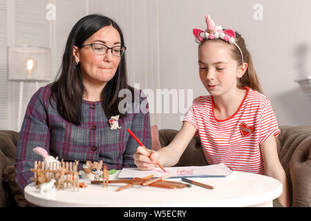 Teen girl on reception at the psychotherapist. Psychotherapy session for children. The psychologist works with the patient. The girl draws pencil with Stock Photo