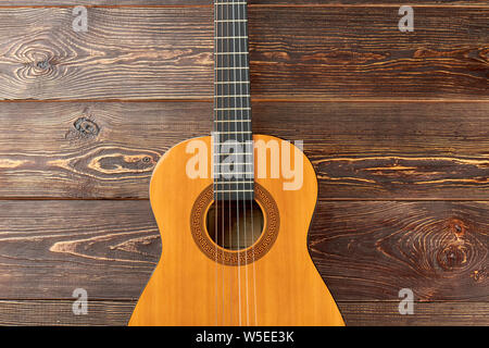 Acoustic guitar on dark wooden background. Stock Photo