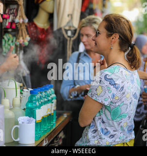 A white woman tourist shops for perfume in a street side market stall in Amman, Jordan. Stock Photo