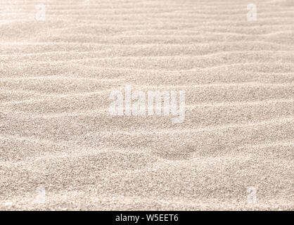 Sandy shore waves. Sand texture on the beach in the morning. Stock Photo