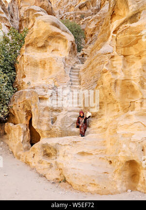 A traditional bedouin woman weaves wool on an authentic hand spinner in Little Petra, Jordan. Stock Photo