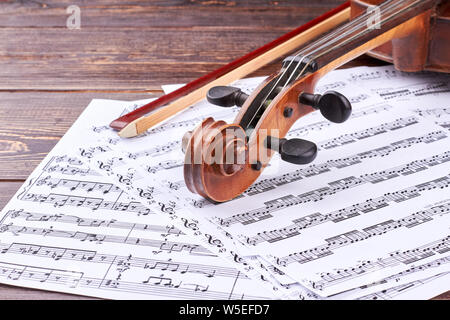 Violin scroll and peg box on musical notes. Stock Photo