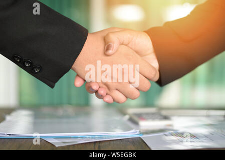 shaking hand concept / two successful asian business women shake hands people in need of exchange and cooperation finishing up meeting in a office Stock Photo