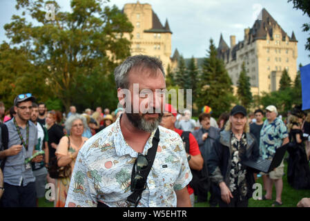 Ottawa, Canada - July 27, 2019:  Ottawa born comedian Tom Green at the rally he invited the public to join in an effort to prevent a proposed addition to the Chateau Laurier that would block the current as seen in the background with a new box like structure. He has been raising awareness for the issue on social media. Stock Photo