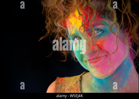 Fun Happy Woman with Holi Festival Powder Paint on her face. Stock Photo
