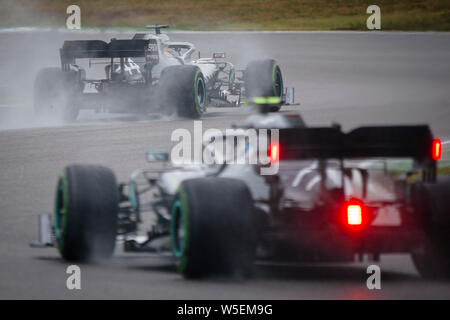 Hockenheim, Germany. 28th July, 2019. Mercedes AMG Petronas F1 Team's British driver Lewis Hamilton (L) and Mercedes AMG Petronas F1 Team's Finnish driver Valtteri Bottas compete during the German F1 Grand Prix race. Credit: SOPA Images Limited/Alamy Live News