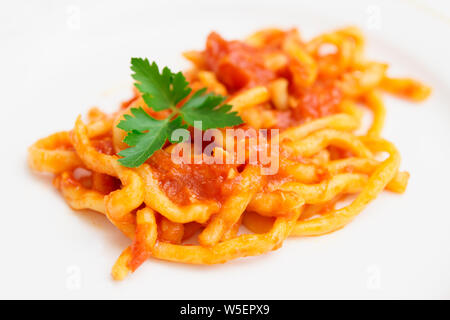 Traditional Tuscan pici pasta with tomato sauce, close-up Stock Photo