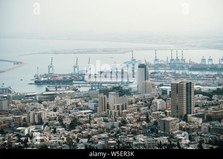 Haifa city landscape. Modern urban buildings in Haifa with many ferry ships, viewing from the air. Aerial view of port of a seaside city shot in early Stock Photo