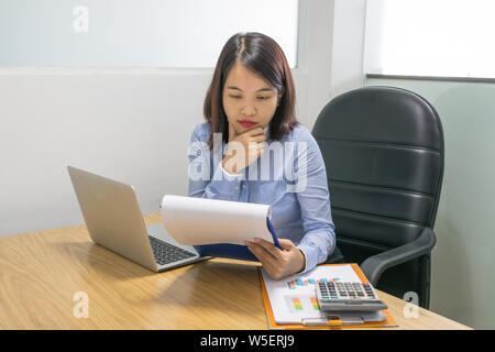 Office employee analyzing graphs on the financial documents Stock Photo