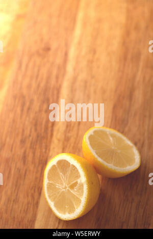 Close up of a sliced lemon on a wooden choppng board. Stock Photo