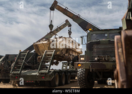 U.S. Marines with Combat Logistics Battalion 2, Combat Logistics Regiment 2, 2nd Marine Logistics Group use AMK-36 to lift a light armored vehicle- 25 on a trailer during a vehicle recovery lane as part of integrated training exercise 5-19 on Marine Corps Air Ground Combat Center Twentynine Palms, California, July 23, 2019. The purpose of ITX 5-19 is to create a challenging, realistic training environment that produces combat-ready forces capable of operating as an integrated Marine Air Ground Task Force. (U.S. Marine Corps photo by Lance Cpl. Scott Jenkins) Stock Photo