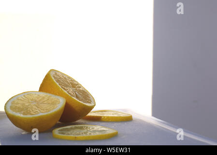 Sliced lemon on a cutting board against a white background. Stock Photo