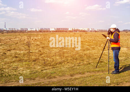 Surveyor worker measures the distance and length using measuring equipment for the construction of a new micro district, copy space, Angle measurement Stock Photo