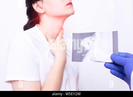 Dr. ENT holds an X-ray picture on the background of a young girl who has inflammation and sore throat due to adenoids, inflammation of the tonsils Stock Photo