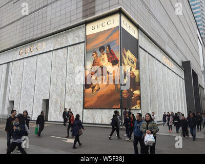 --FILE--Pedestrians walk past a boutique store of Gucci in Wuhan city, central China's Hubei province, 14 April 2018.   Half of Chinese luxury spendin Stock Photo