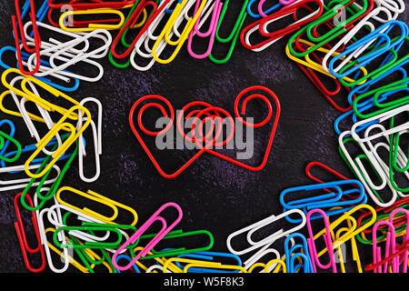 Colored paper clips isolated on dark background Stock Photo