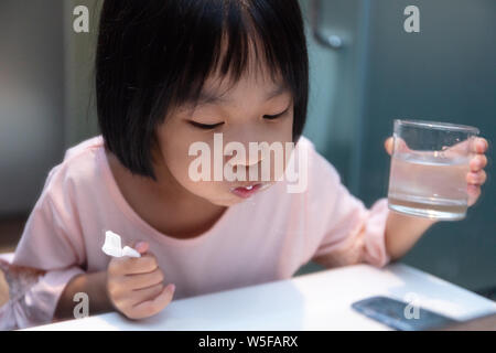 Asian Little Chinese Girl brushing her teeth in the restroom Stock Photo
