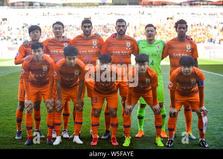 Players of the starting line-up of China's Shandong Luneng pose for photos before competing against Japan's Kashima Antlers in their Team E second rou Stock Photo