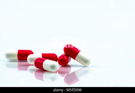 Red-white capsule pill isolated on white background. Antibiotic drug resistance. Antimicrobial capsule pills. Pharmacy drugstore symbol. Pharmacy. Stock Photo