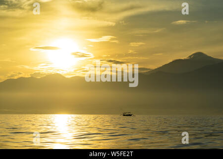 Sunrise view over tourists waiting for wild dolphin at Lovina beach in Bali, Indonesia. Stock Photo