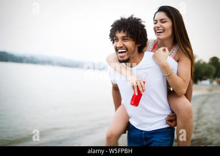 Smiling couple having fun over sky background. Holidays, vacation, love and friendship concept