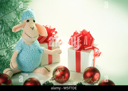 cute toy sheep and boxes with gifts on Christmas background Stock Photo