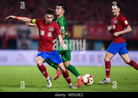 Brazilian football player Olivio da Rosa, also known as Ivo, left, of Henan Jianye passes the ball against English football player Nico Yennaris, known in China as Li Ke, of Beijing Sinobo Guoan in their 20th round match during the 2019 Chinese Football Association Super League (CSL) in Zhengzhou city, central China's Henan province, 27 July 2019. Henan Jianye defeated Beijing Sinobo Guoan 1-0.