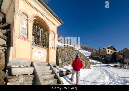 Italy, Lombardy, Retiche Alps, Camonica Valley, snowshoeing on the trail to the ancient alpine church of San Clemente, shrine Stock Photo