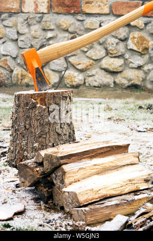 ax stuck in the stump winter season Stock Photo