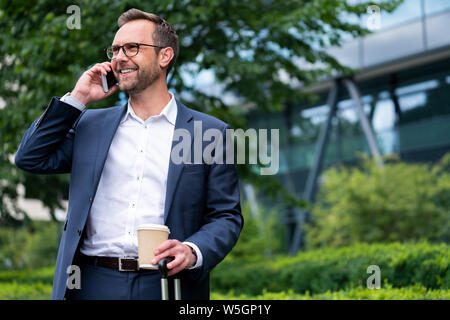 Mature Businessman Taking Phone Call On Mobile Phone Standing Outside Office Building Stock Photo