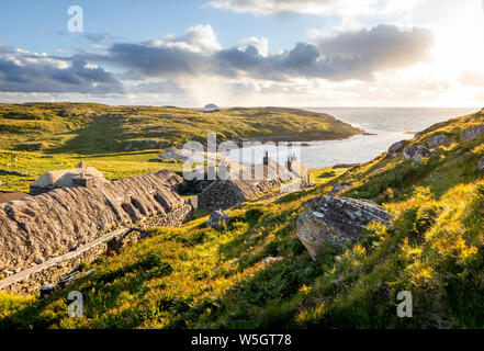 Gearrannan, Shottland- June 20, 2018: Gearrannan blackhouse village with thatched roof houses on Isle of Lewis in a golden evening light Stock Photo