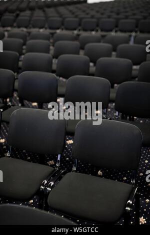 Black chairs in big empty congress room, front view Stock Photo